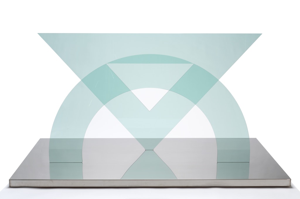 A translucent blue geometric sculpture on a metal base.