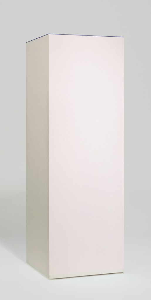 A rectangular white pedistal sitting in a white space.