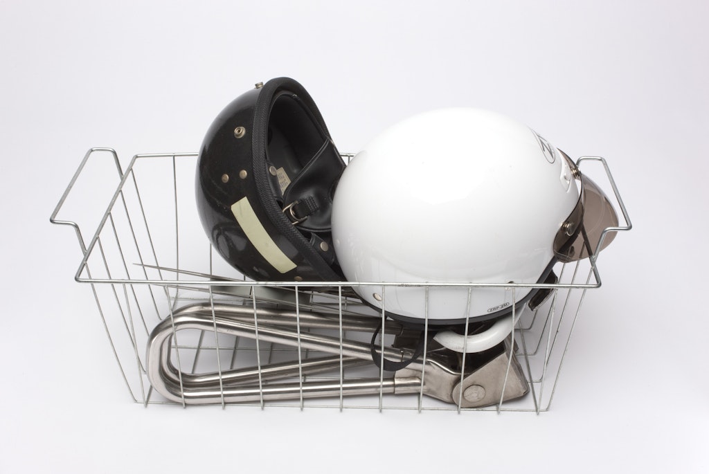 A metal wire basket with helmets inside