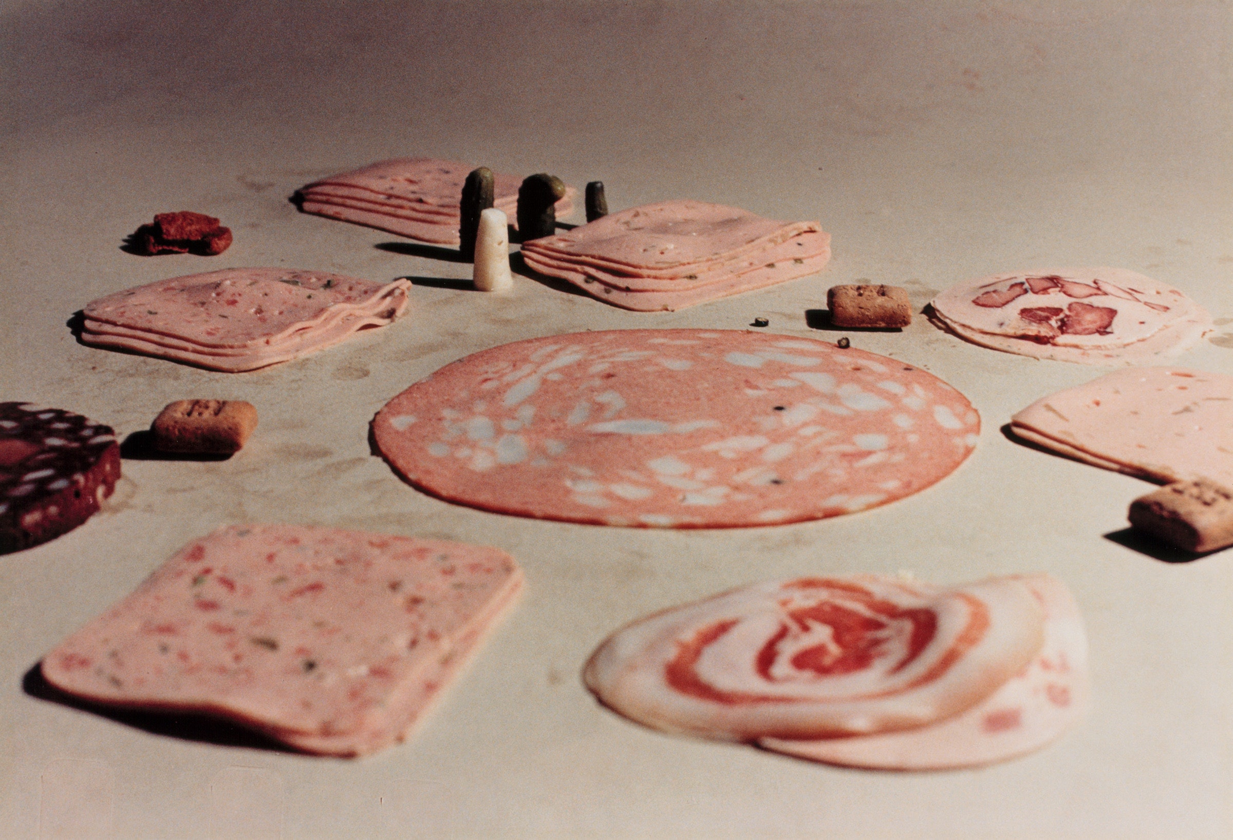 Photograph of cute deli meats on a flat surface.