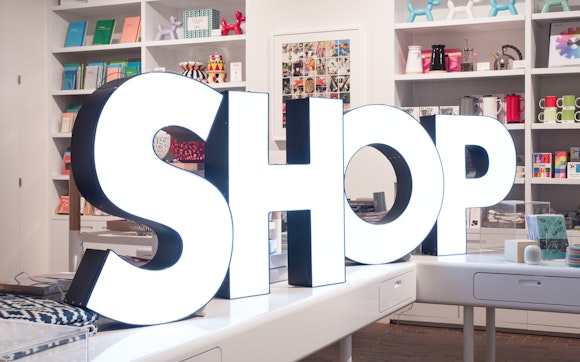 Large lit up letters spell out the word "Shop" in the Walker Shop.